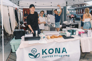 Kona Coffee Roasters team at a waterfront market booth